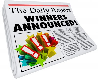 Winners Announced stamped across a newspaper